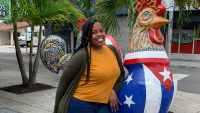Woman standing next to statue.